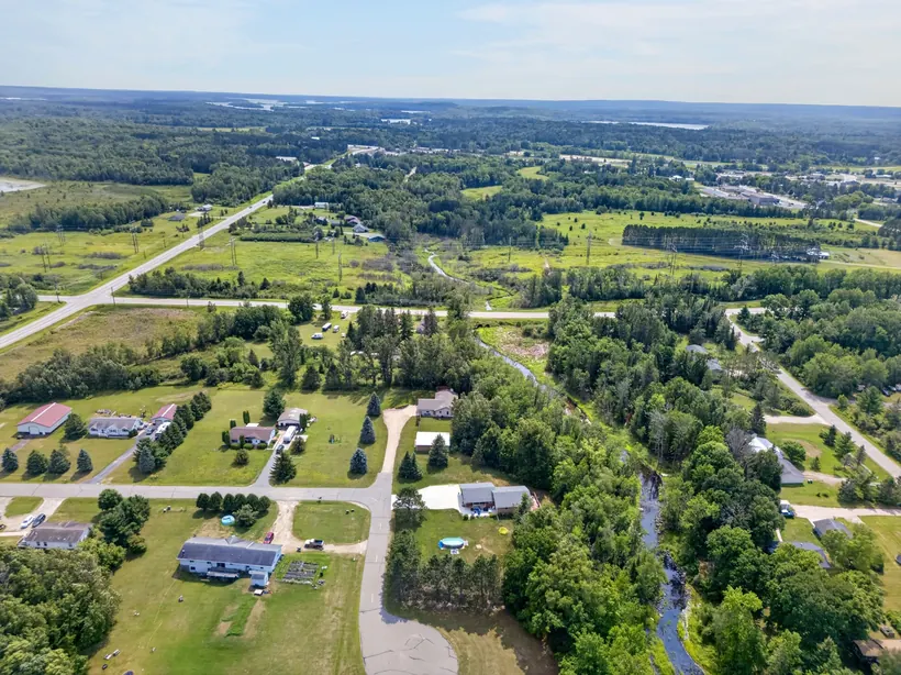 Wide aerial view of the property, creek, and Cohasset surroundings